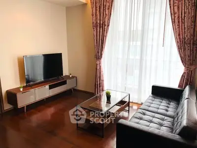 Modern living room with sleek furniture and large window, perfect for relaxation and entertainment.