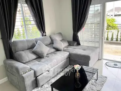 Modern living room with plush gray sofa and balcony view, perfect for relaxation and entertaining.