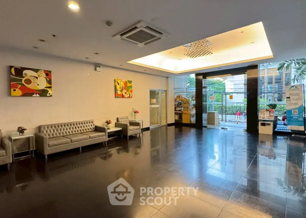 Elegant building entrance with modern seating and art decor, showcasing a welcoming atmosphere.