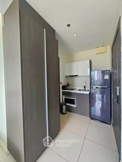 Modern compact kitchen with sleek cabinetry and appliances, ideal for urban living.