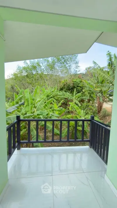 Charming balcony with lush green garden view, perfect for relaxation and enjoying nature.