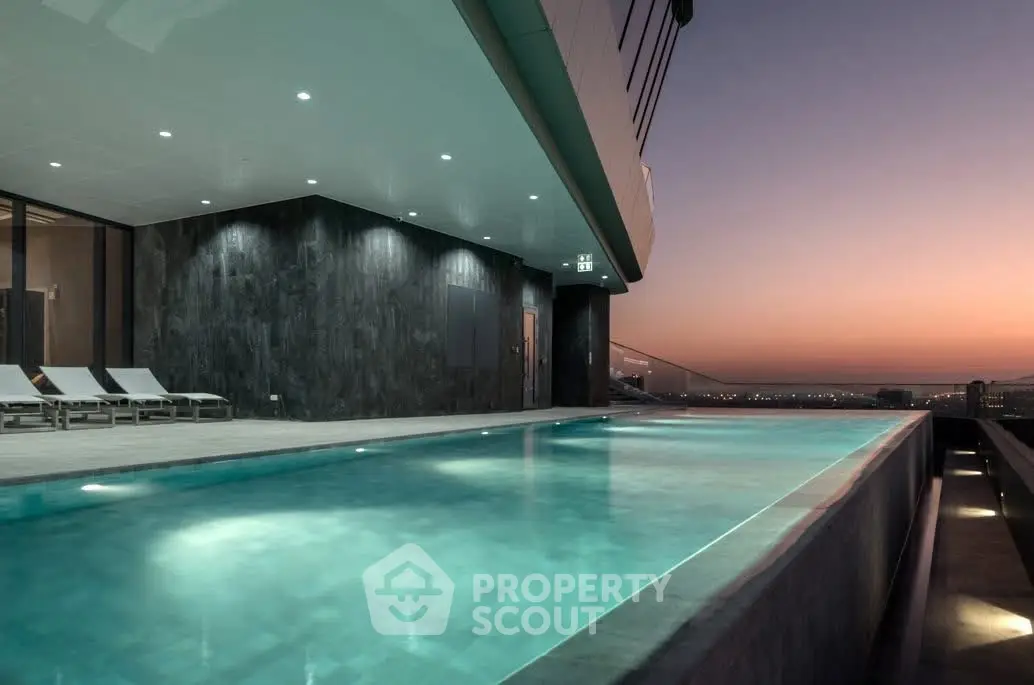 Luxurious rooftop pool with stunning sunset view in modern high-rise building.