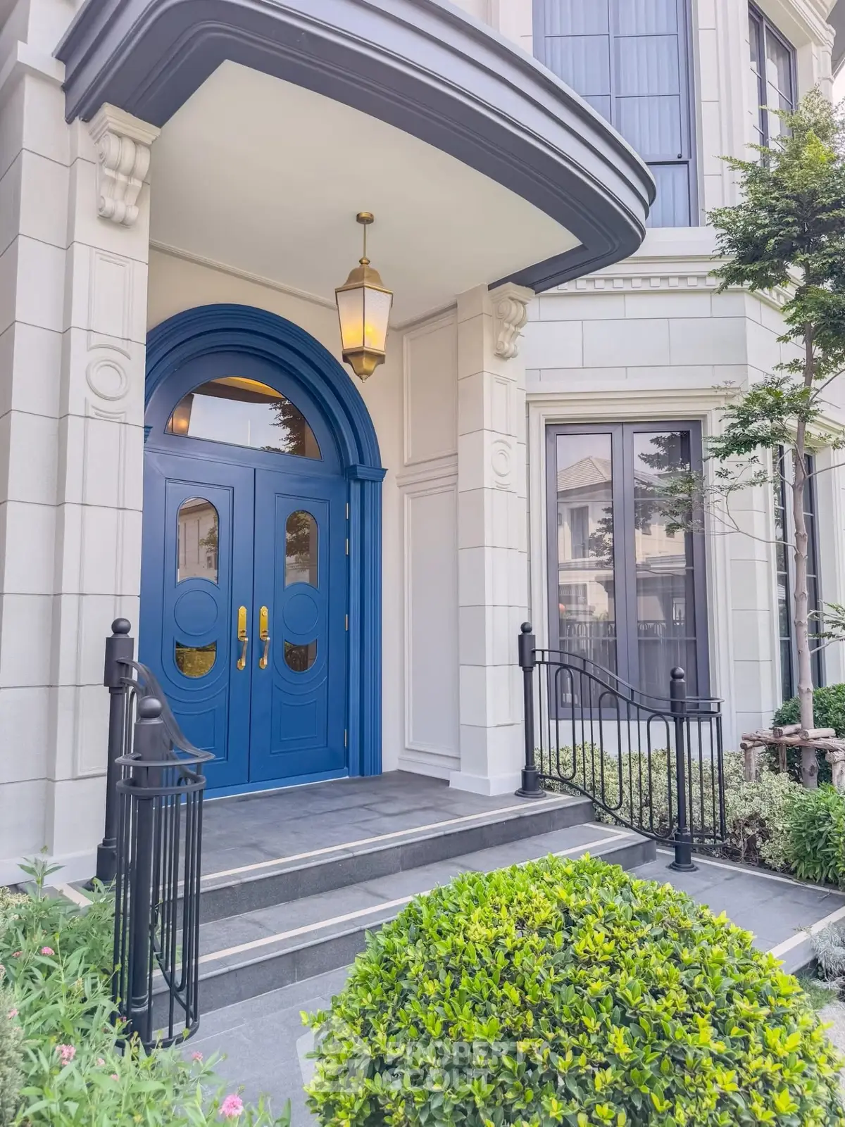 Elegant entrance with blue double doors and classic architectural details