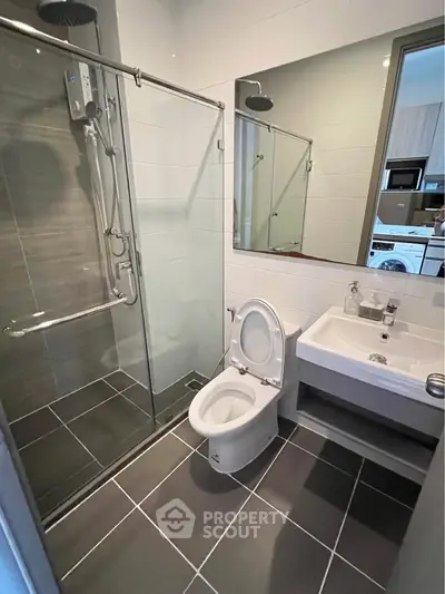 Modern bathroom with glass shower and sleek fixtures in a contemporary apartment.