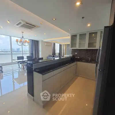 Luxurious open-layout kitchen with modern appliances and stunning city view in high-rise apartment.