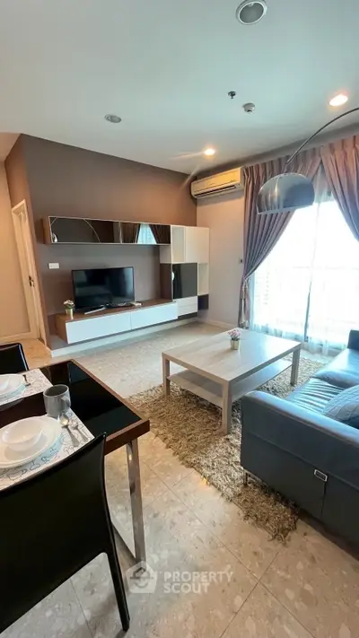 Modern living room with stylish furniture and large windows in a cozy apartment.