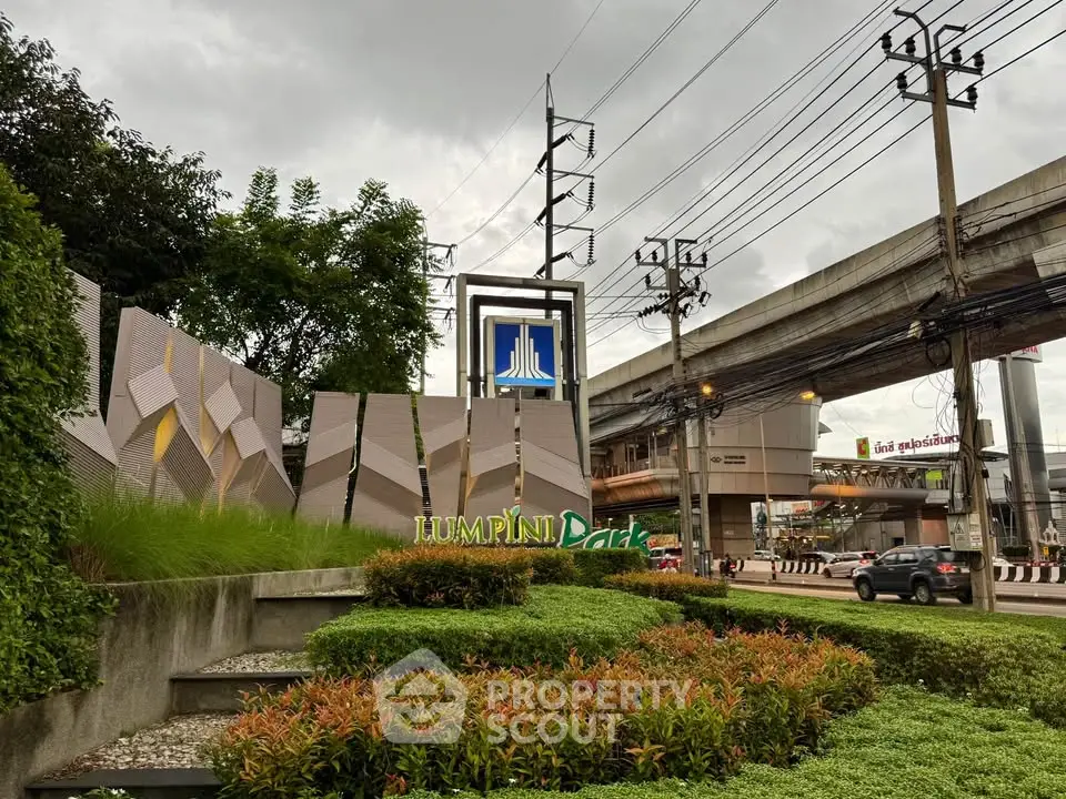 Modern urban garden with architectural signage and city infrastructure view.