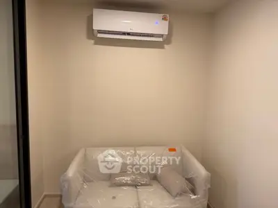 Cozy small living area with air conditioning and plastic-covered sofa