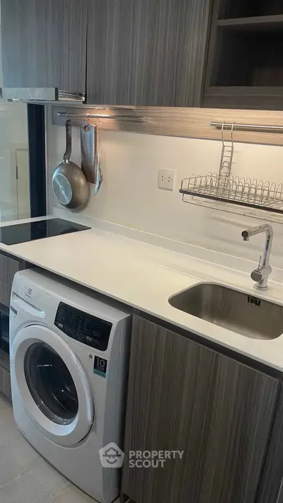 Modern kitchen with sleek cabinetry and built-in washing machine