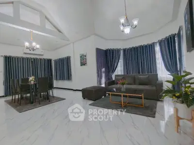 Spacious living room with elegant decor and large windows, perfect for family gatherings.