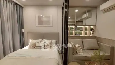Modern bedroom with cozy bed and stylish sofa in a well-lit apartment.