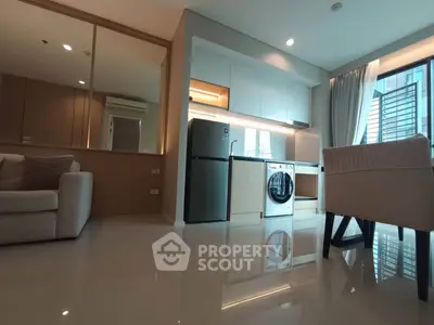 Modern living room with sleek kitchen and appliances in a stylish apartment