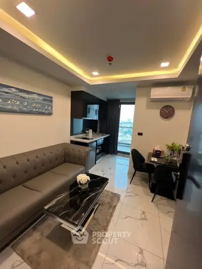 Modern living room with open kitchen and city view, featuring elegant decor and stylish furniture.