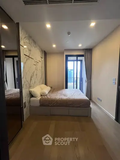 Modern bedroom with stylish decor and balcony access in luxury apartment