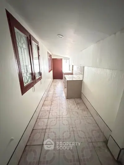 Narrow kitchen with tiled floor and closed layout in a compact apartment.