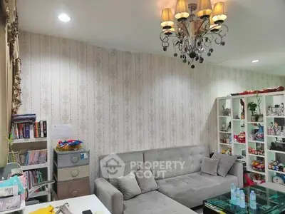 Cozy living room with elegant chandelier and modern gray sofa