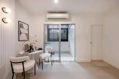 Modern dining area with stylish decor and sliding glass doors leading to a bright kitchen.