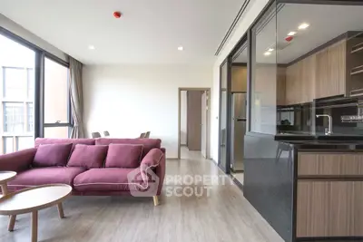 Modern living room with open kitchen and stylish furniture in a bright apartment.