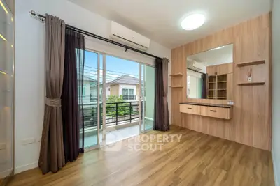 Spacious bedroom with balcony access and wooden flooring in modern home