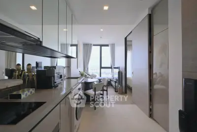 Modern kitchen with sleek appliances and open layout leading to a bright living area with city view.