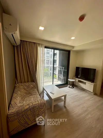 Modern living room with balcony view, featuring sleek furniture and natural light.
