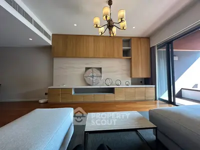 Spacious modern living room with elegant wooden cabinetry and stylish chandelier