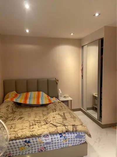 Cozy bedroom with modern lighting and mirrored wardrobe, perfect for relaxation.