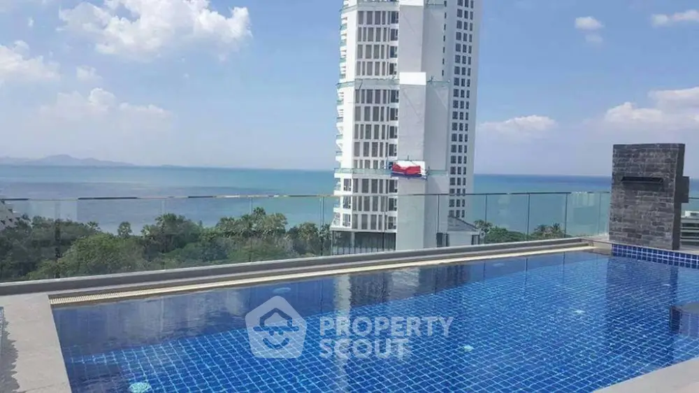 Stunning rooftop pool with panoramic ocean view and modern high-rise building.