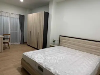 Spacious bedroom with modern furnishings and natural light