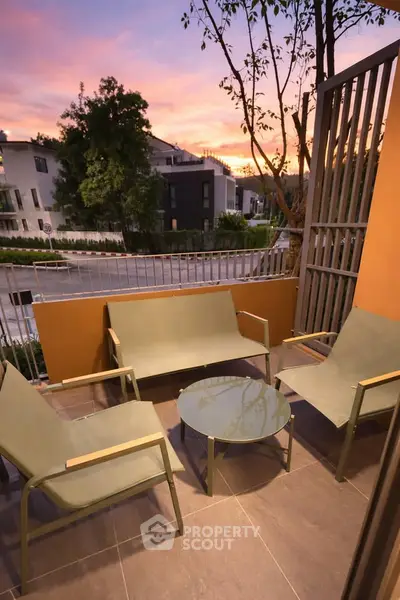 Charming balcony with modern seating and sunset view, perfect for relaxation and entertaining.