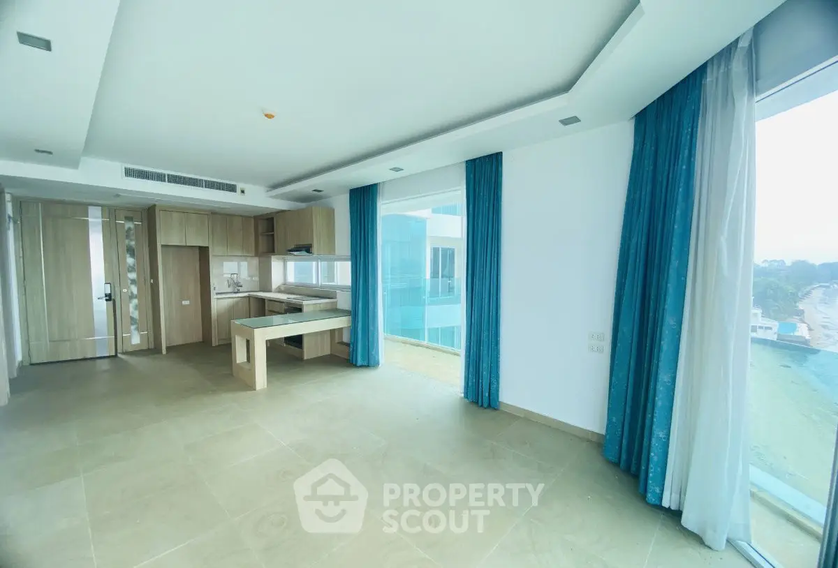 Modern open-plan living space with large windows and stylish kitchen in luxury apartment.