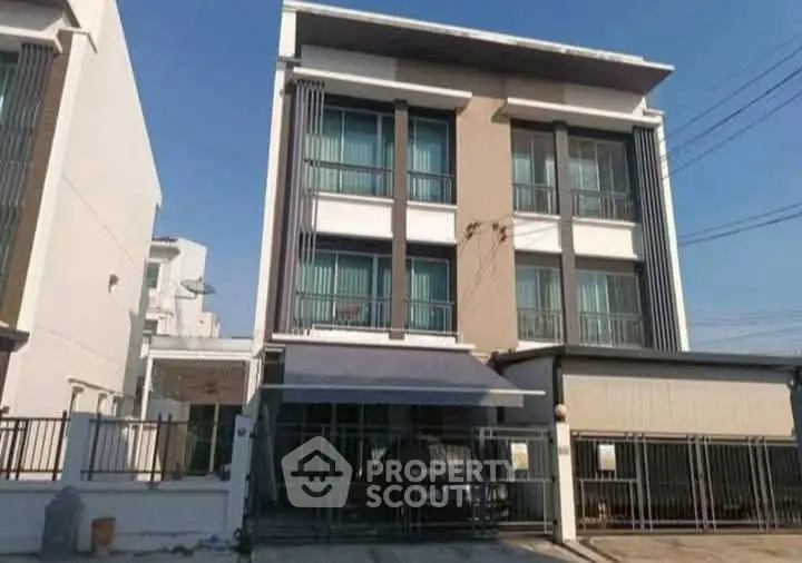 Modern three-story townhouse with gated parking and sleek facade