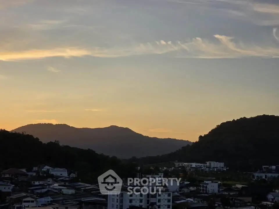 Stunning sunset view over a serene residential area with hills in the background.