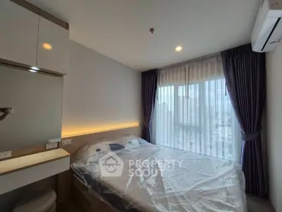 Modern bedroom with city view, featuring stylish decor and ample natural light.