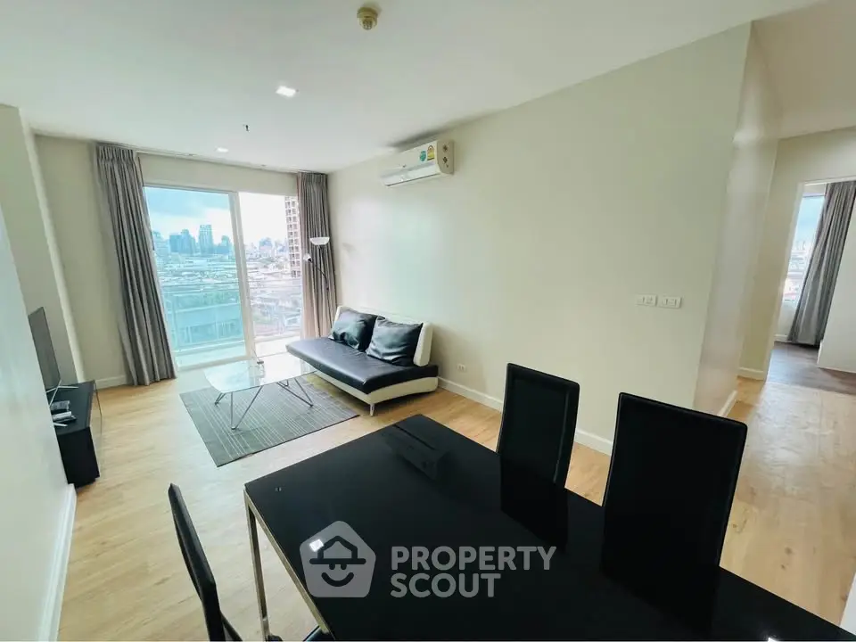 Modern living room with city view, sleek furniture, and natural light.