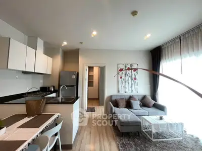 Modern open-layout living room with stylish kitchen and cozy seating area, perfect for urban living.