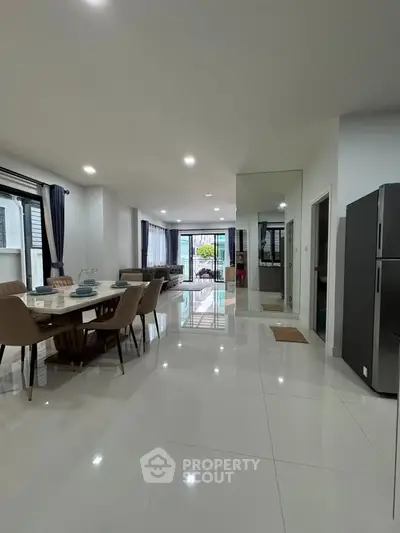 Spacious modern living and dining area with sleek design and ample natural light.