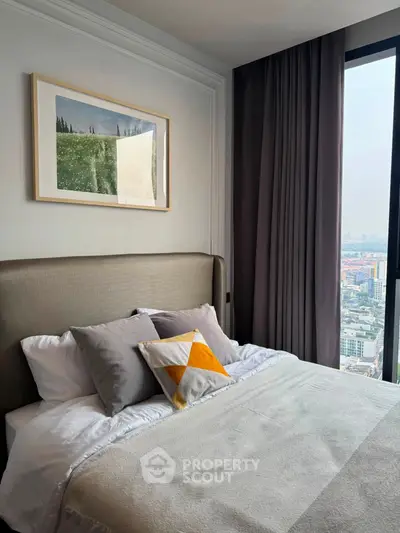 Modern bedroom with city view, elegant decor, and large window for natural light.