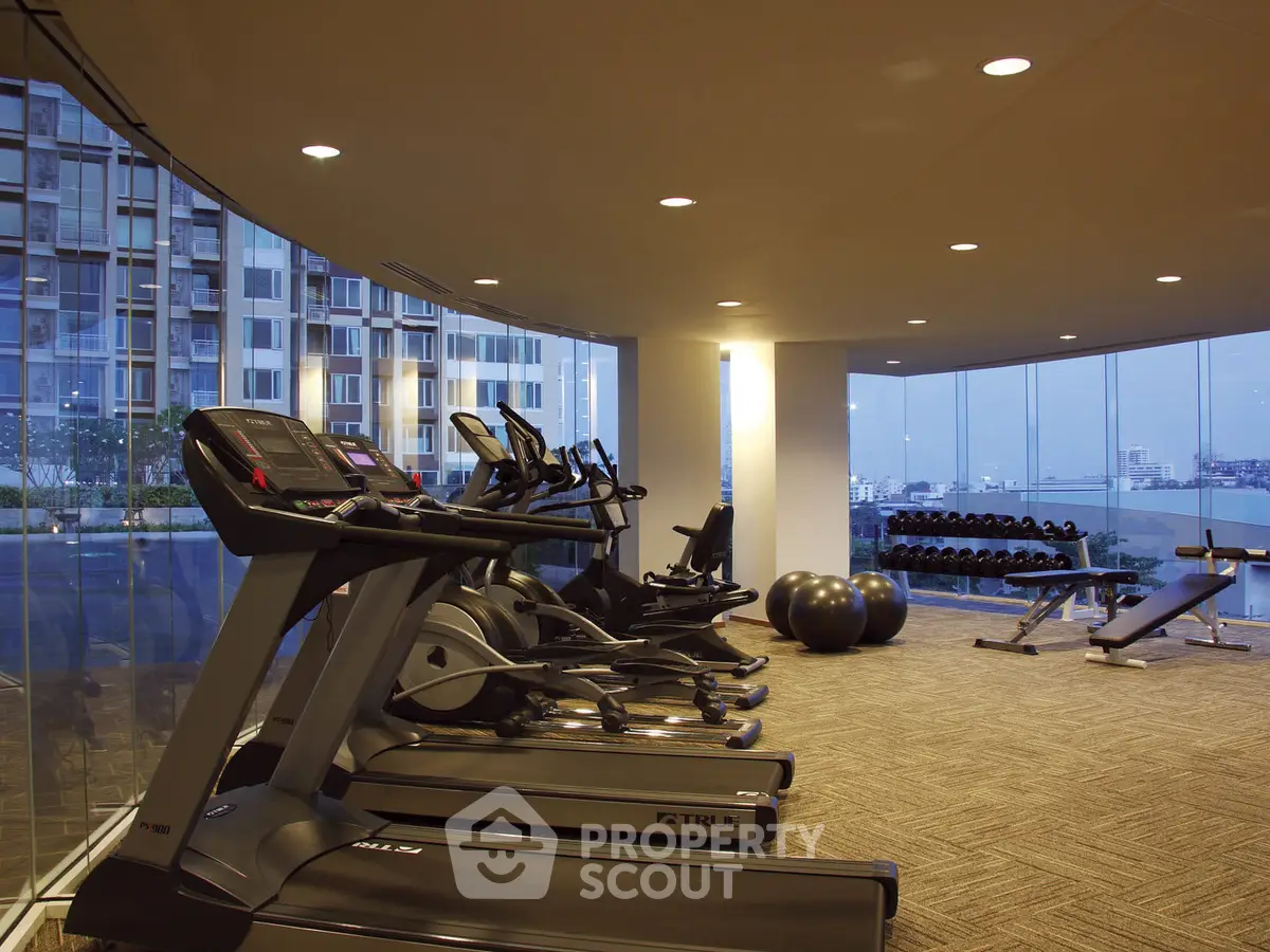 Modern gym with panoramic city views and state-of-the-art fitness equipment.