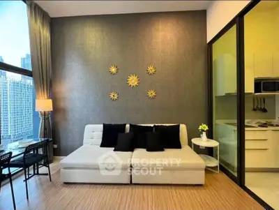Modern living room with stylish decor and adjacent kitchen in a high-rise apartment with city view.