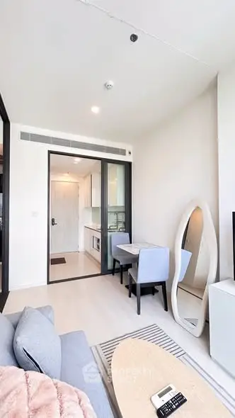 Modern living room with stylish furniture and open kitchen layout in a bright apartment.
