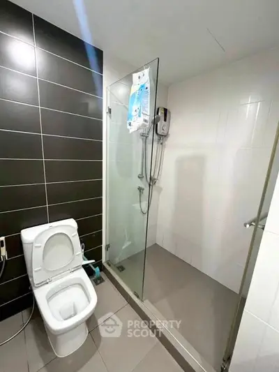 Modern bathroom with glass shower and sleek black tile accents
