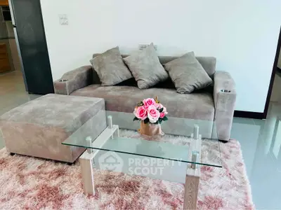 Modern living room with plush sofa, glass coffee table, and elegant decor in a stylish apartment.