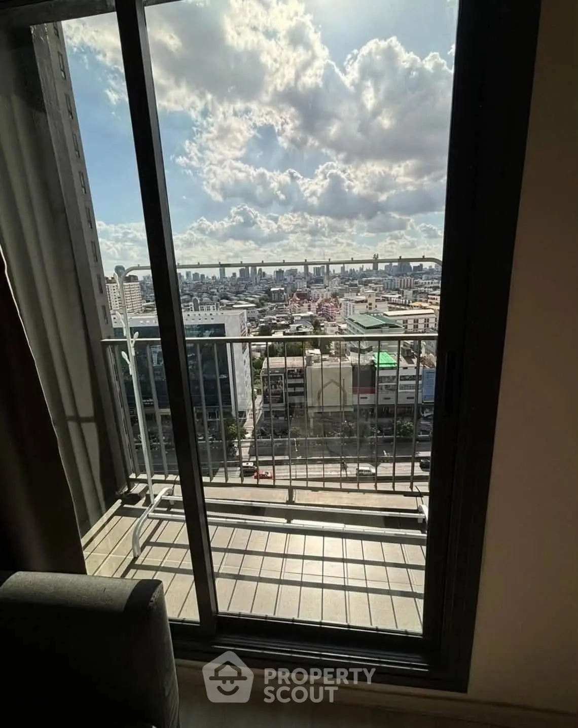 Stunning cityscape view from a high-rise balcony with expansive skyline and clouds.