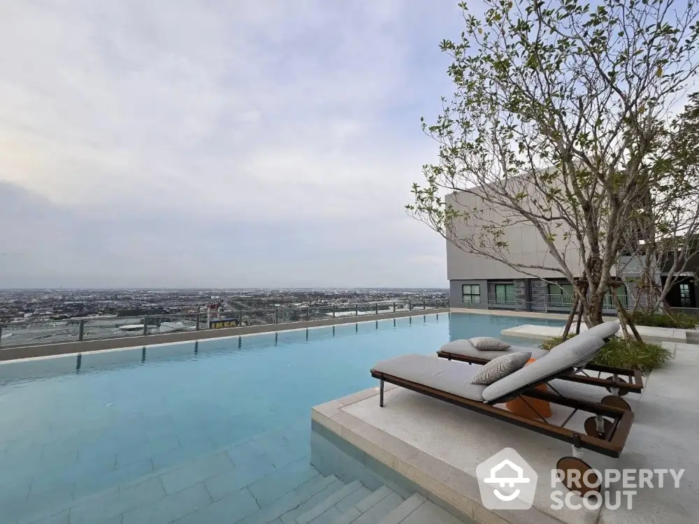 Luxurious rooftop pool with stunning city view and modern lounge chairs