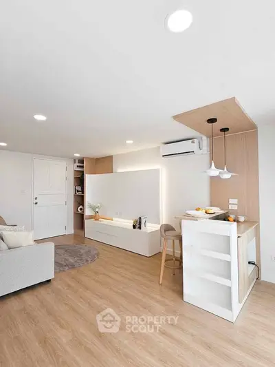 Modern living room with open kitchen, featuring sleek design and cozy ambiance.