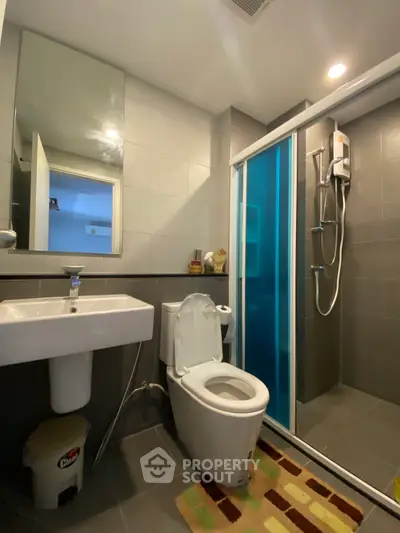 Modern bathroom with shower and sleek fixtures in contemporary apartment.