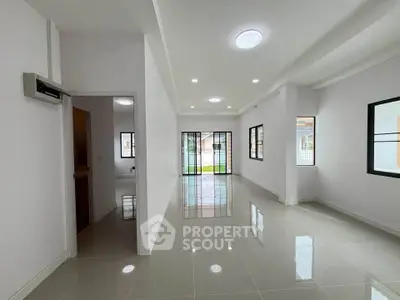 Spacious modern living room with glossy tiled floors and large windows for natural light.
