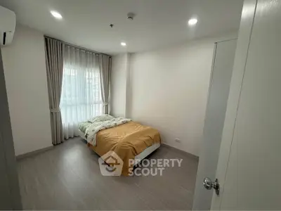 Modern bedroom with natural light and minimalist decor in a stylish apartment.
