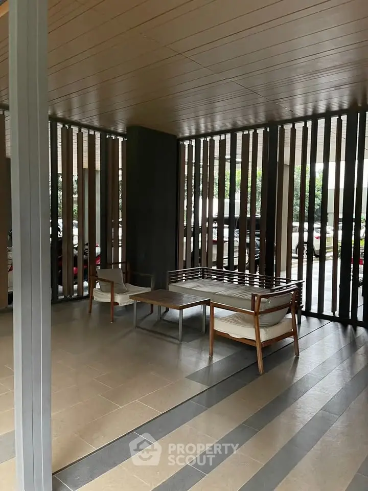 Modern building entrance with stylish seating area and sleek design.